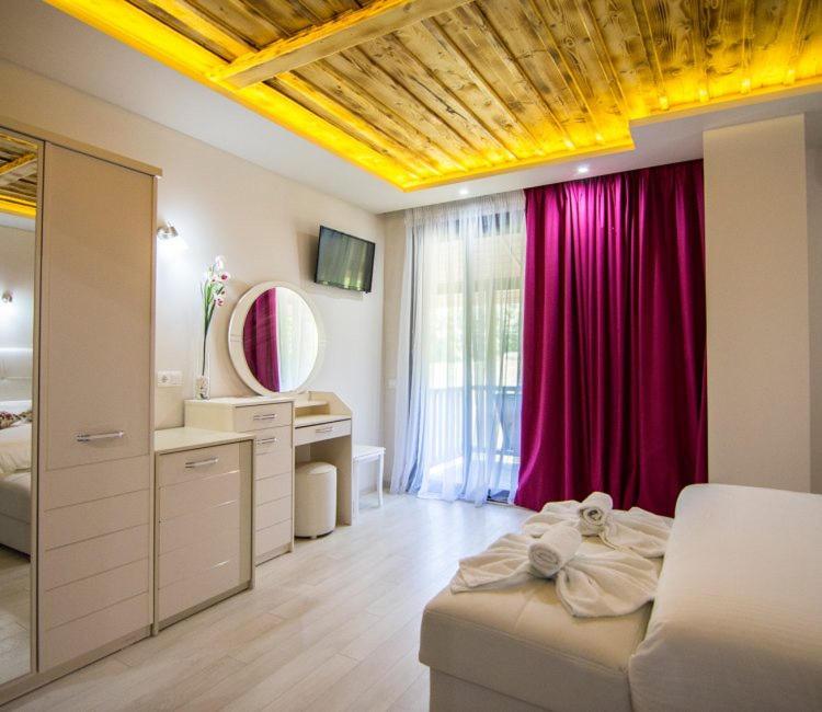 a bedroom with a bed and a vanity and a mirror at Archontiko Liamas in Stavros