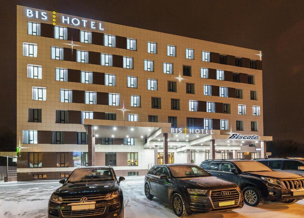 dwa samochody zaparkowane przed hotelem w obiekcie Bishotel w mieście Lipieck