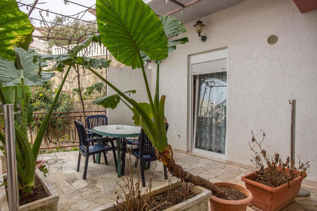 un patio con tavolo, sedie e piante di Apartments Fortuna 3427 a Lokva Rogoznica