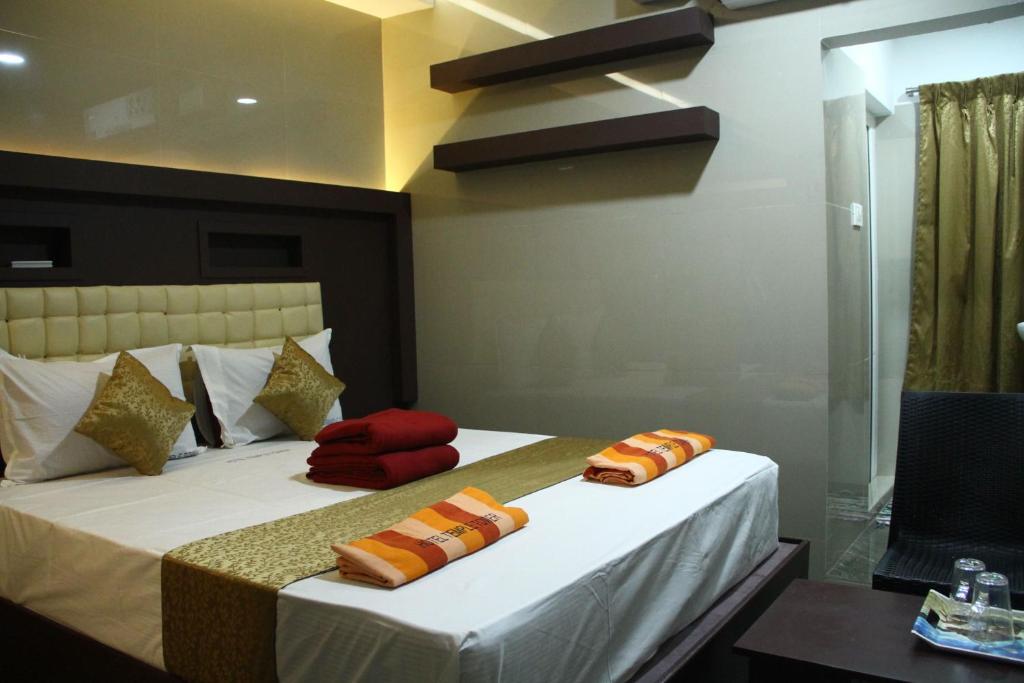 a hotel room with a bed and a table at Hotel Temple Tower Rameswaram in Rāmeswaram