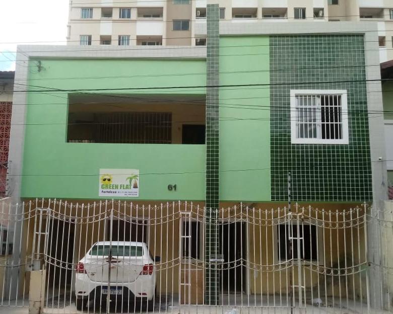 a car parked in front of a green building at Green Flat Fortaleza in Fortaleza