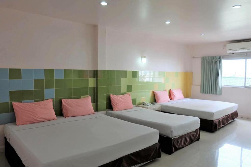 Pokój z 2 łóżkami i różowymi poduszkami w obiekcie Center Mansion at Hatyai w mieście Hat Yai