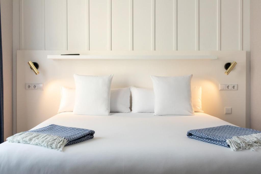 a white bed with two pillows on top of it at Ramirez Flats Valencia in Valencia