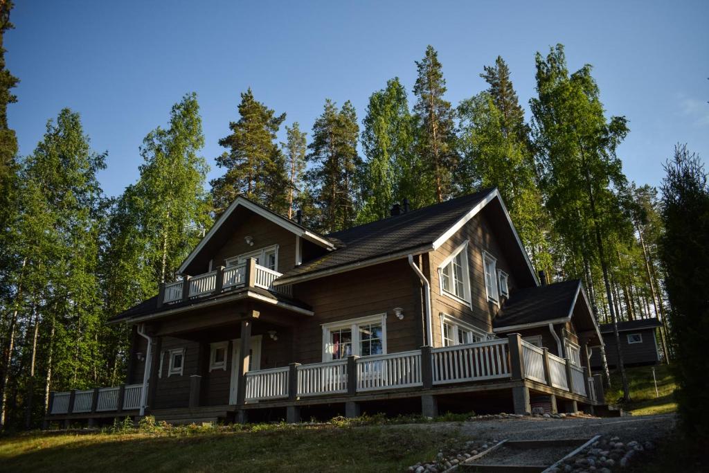 a log home with a porch and a balcony at Loma-Autio Tähti Villa in Puumala