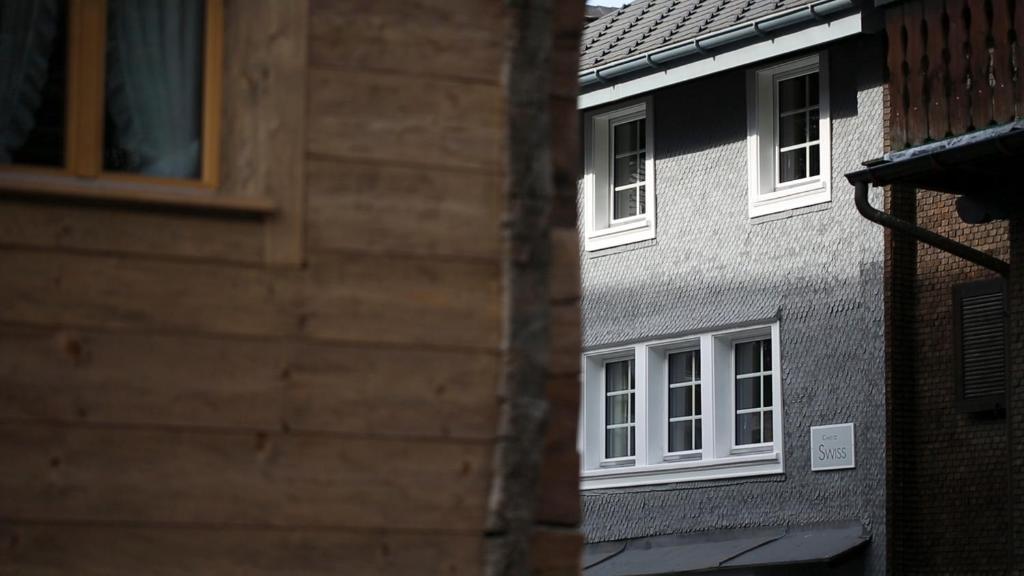 einen seitlichen Blick auf ein Gebäude mit weißen Fenstern in der Unterkunft Chalet Swiss Andermatt in Andermatt
