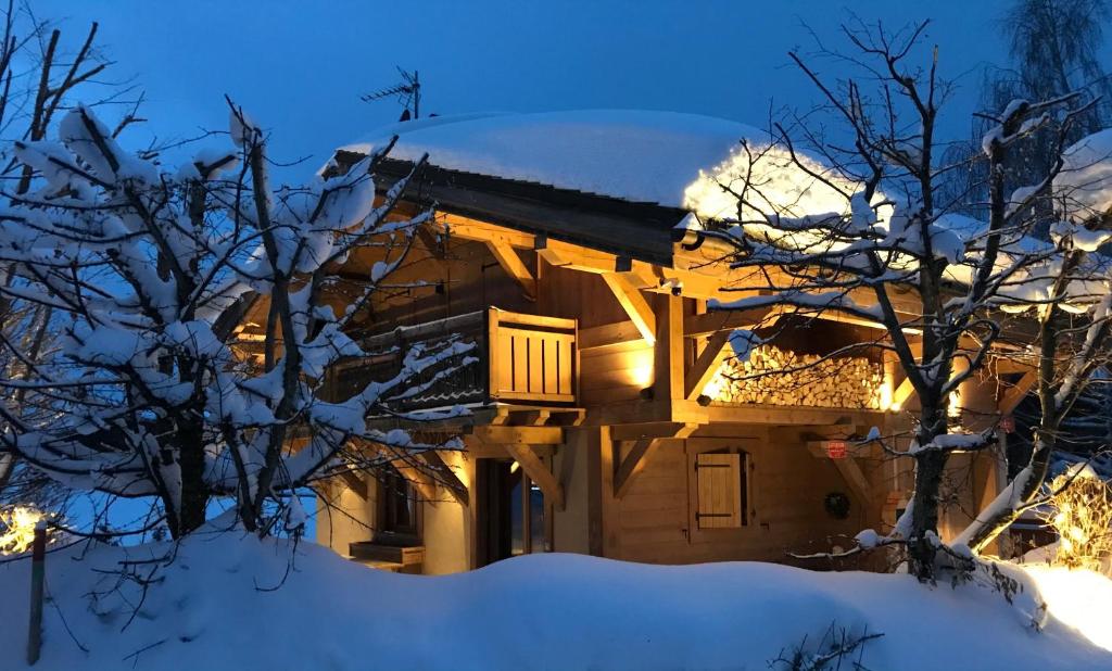 a house covered in snow at night at Chalet Megeve, idéal familles proche ski et centre village in Megève