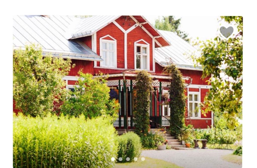 a red house with a black fence in front of it at Captivating 1-Bed Studio in Avesta