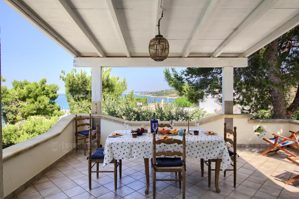 a table on a patio with a view of the ocean at Sole A Sunset Bay - San Gregorio in Patù