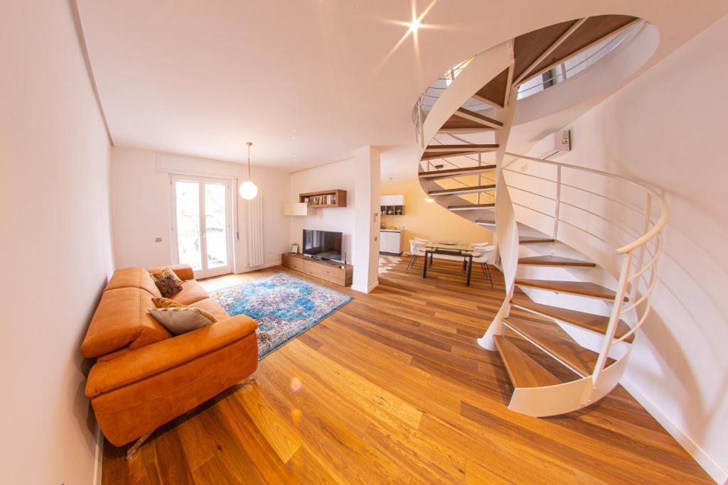 Una escalera de caracol en una sala de estar con un sofá. en Figoli guesthouse, en Oristano