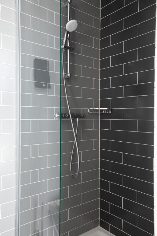 a bathroom with a shower with black tiles at Holiday Inn Express Amsterdam - North Riverside by IHG in Amsterdam
