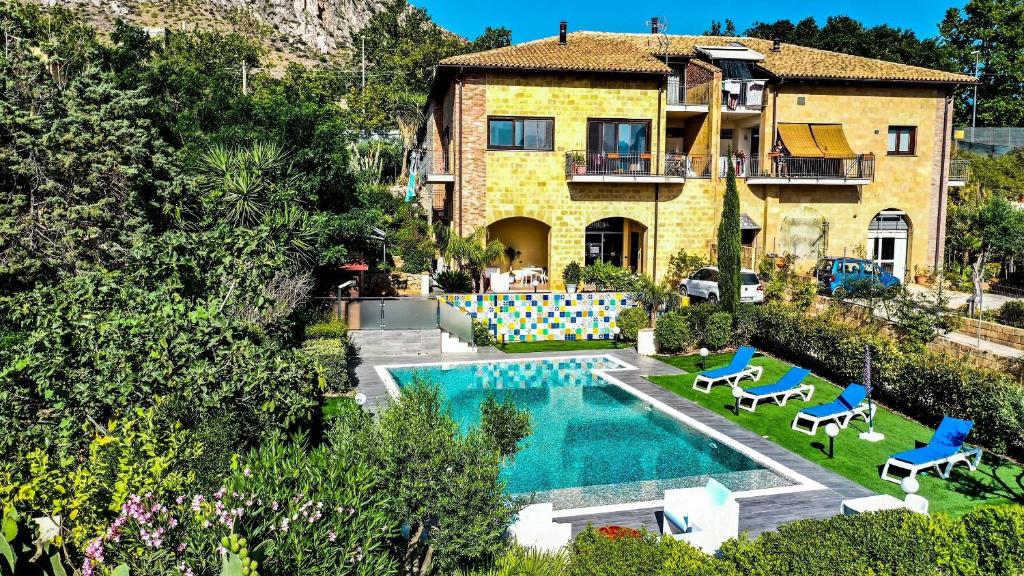 une villa avec une piscine en face d'une maison dans l'établissement b&b Pirriera, à Bagheria