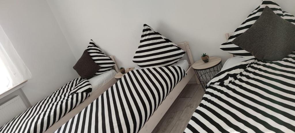 two beds in a room with black and white pillows at Schöne, renovierte und optimal gelegene Wohnung in Weißkirchen