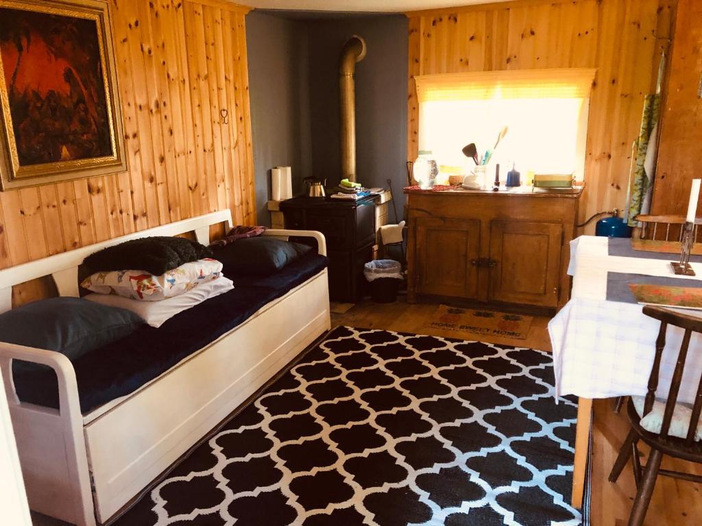 a dog laying on a bed in a room at Tiny hut in the forest overlooking the river in Avesta