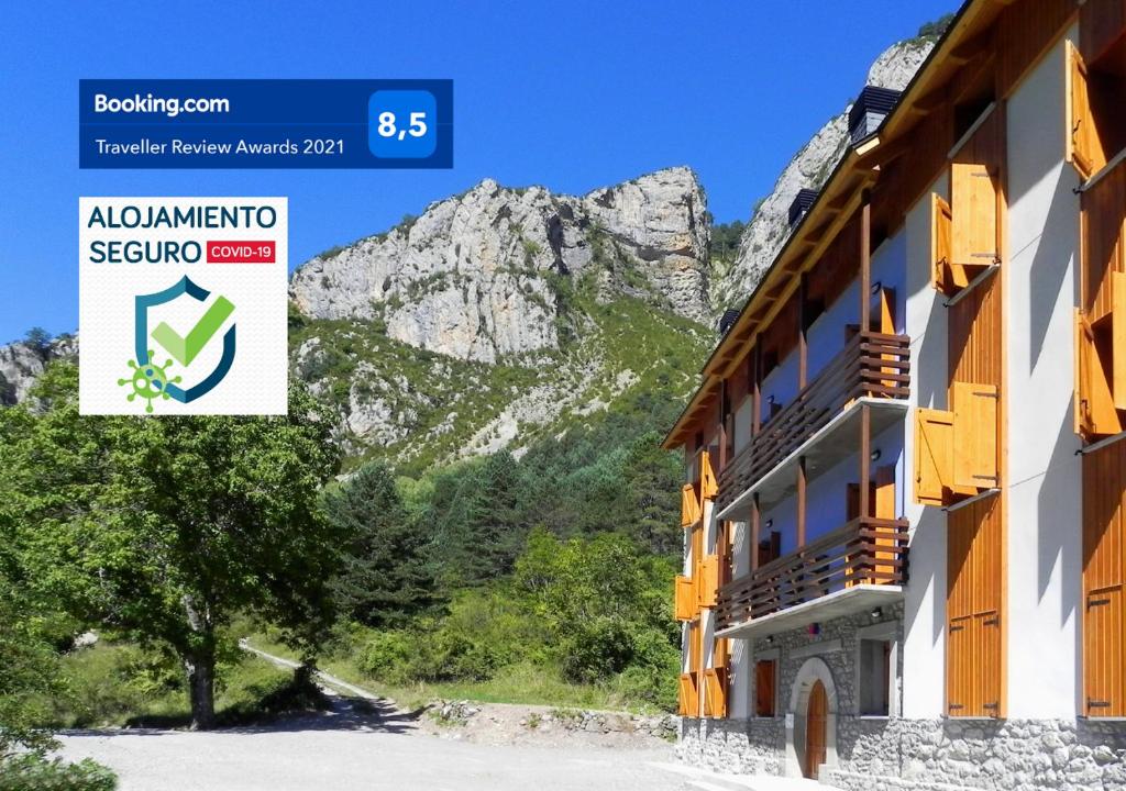 una señal para un hotel con montañas en el fondo en Caserón Baruca, en Bielsa