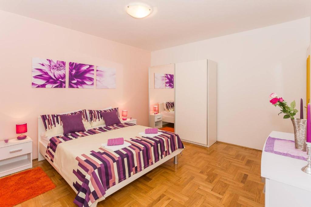 een slaapkamer met een paars en wit bed bij Apartments Zenta Split in Split