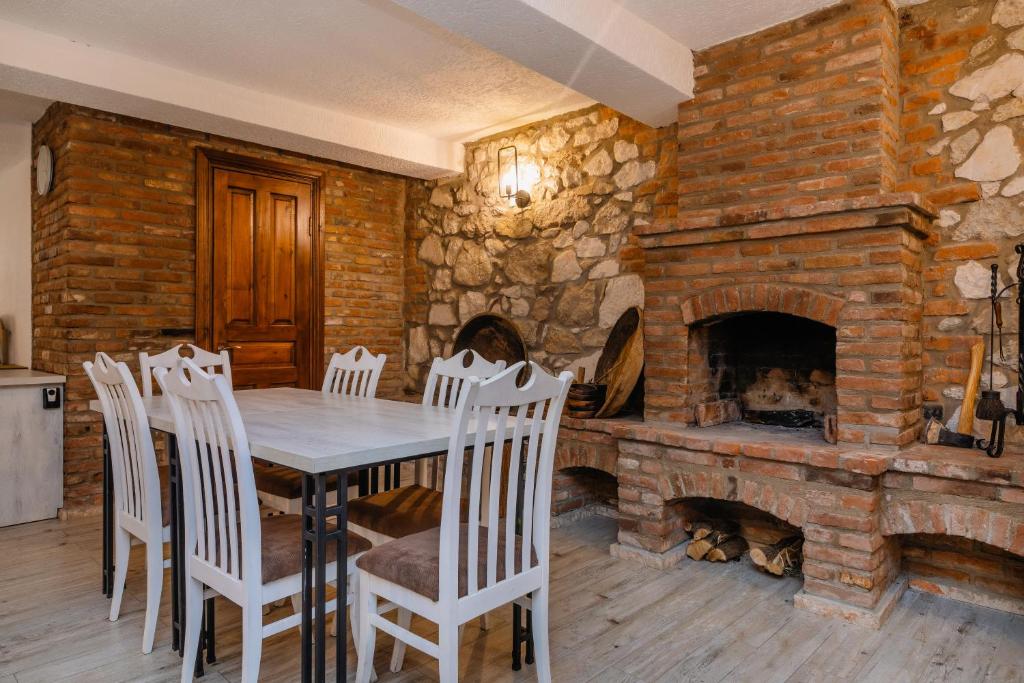 a dining room with a table and a stone fireplace at Hotel Green Town in Kutaisi
