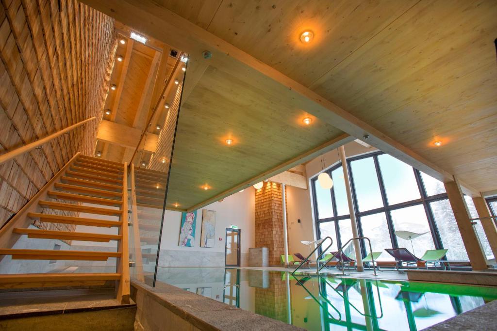 a house with a swimming pool and a staircase at Hotel Glemmtalerhof in Saalbach Hinterglemm