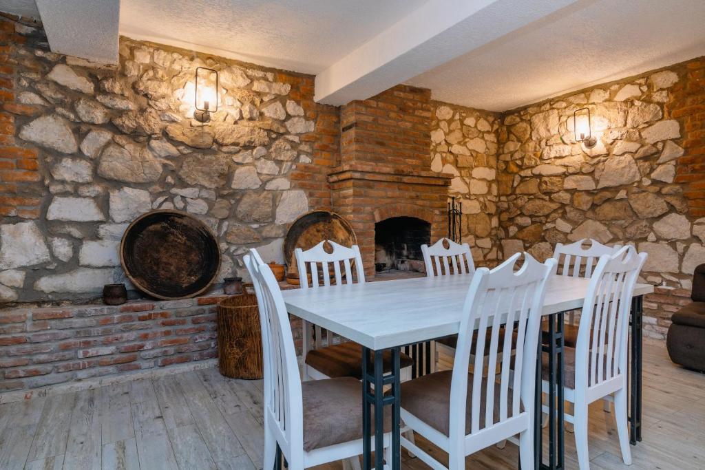 a dining room with a white table and chairs at Hotel Green Town in Kutaisi