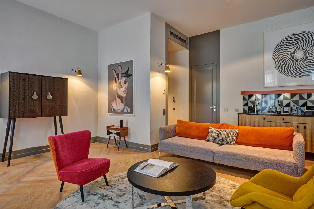 a living room with a couch and a table and chairs at H15 Boutique Hotel, Warsaw, a Member of Design Hotels in Warsaw