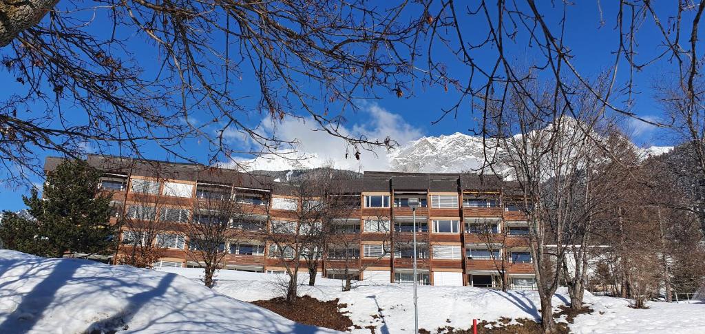 a building with a snow covered mountain in the background at Tgesa Sunnmatt Nr. 13 in Savognin