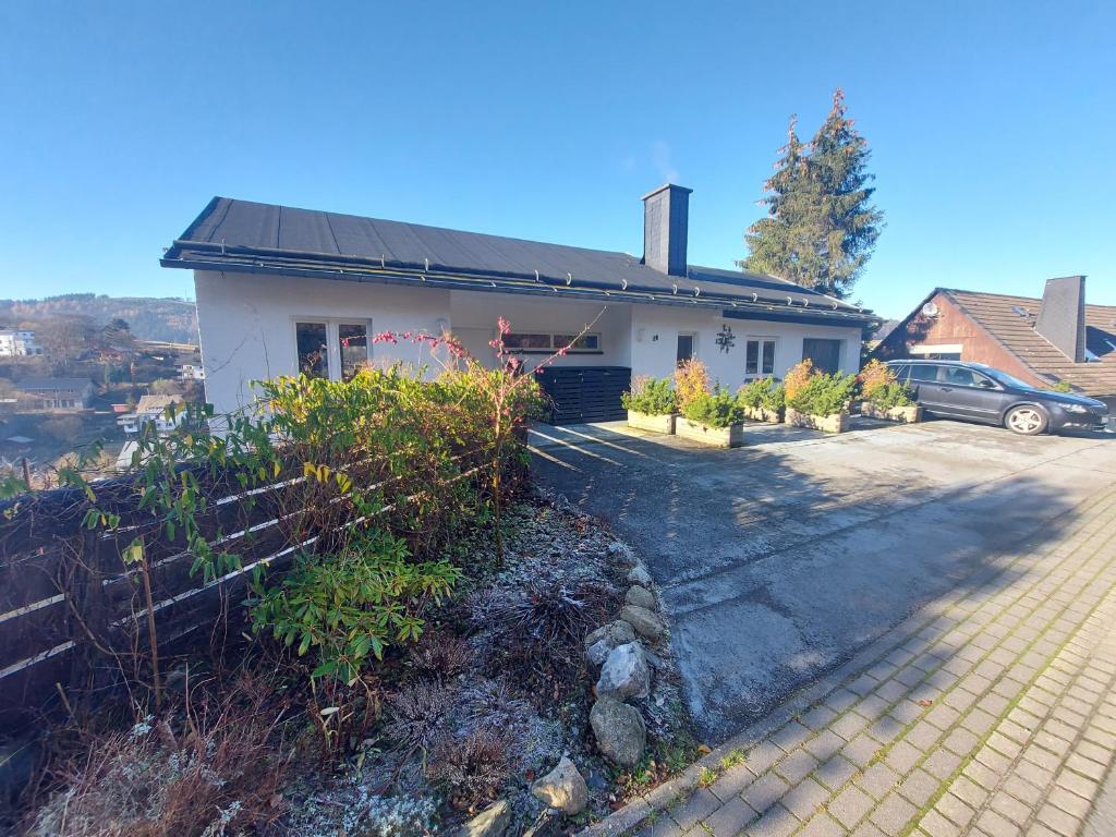 una casa blanca con una valla delante en Panoramablick Willingen Schwalefeld, en Willingen