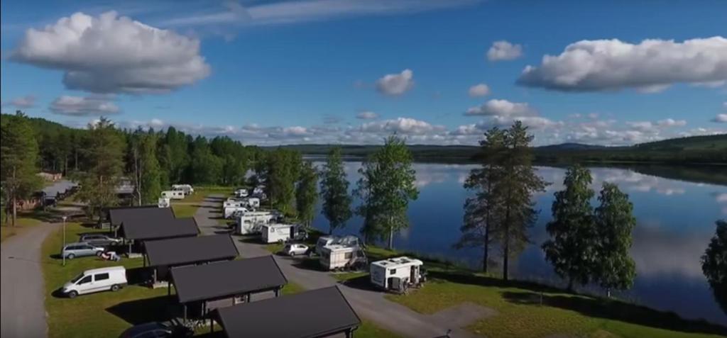 Vista ariale di un gruppo di camper parcheggiato vicino a un lago di Saiva Camping & Stugby a Vilhelmina