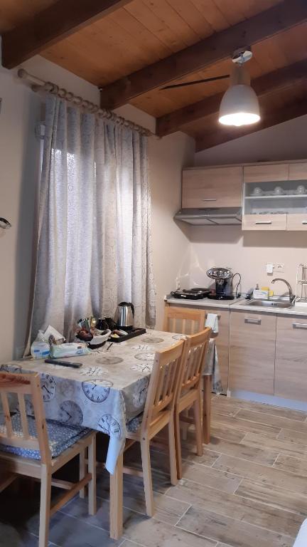 kuchnia ze stołem, krzesłami i stołem oraz kuchnia w obiekcie Room near the Airport w mieście Pikérmion