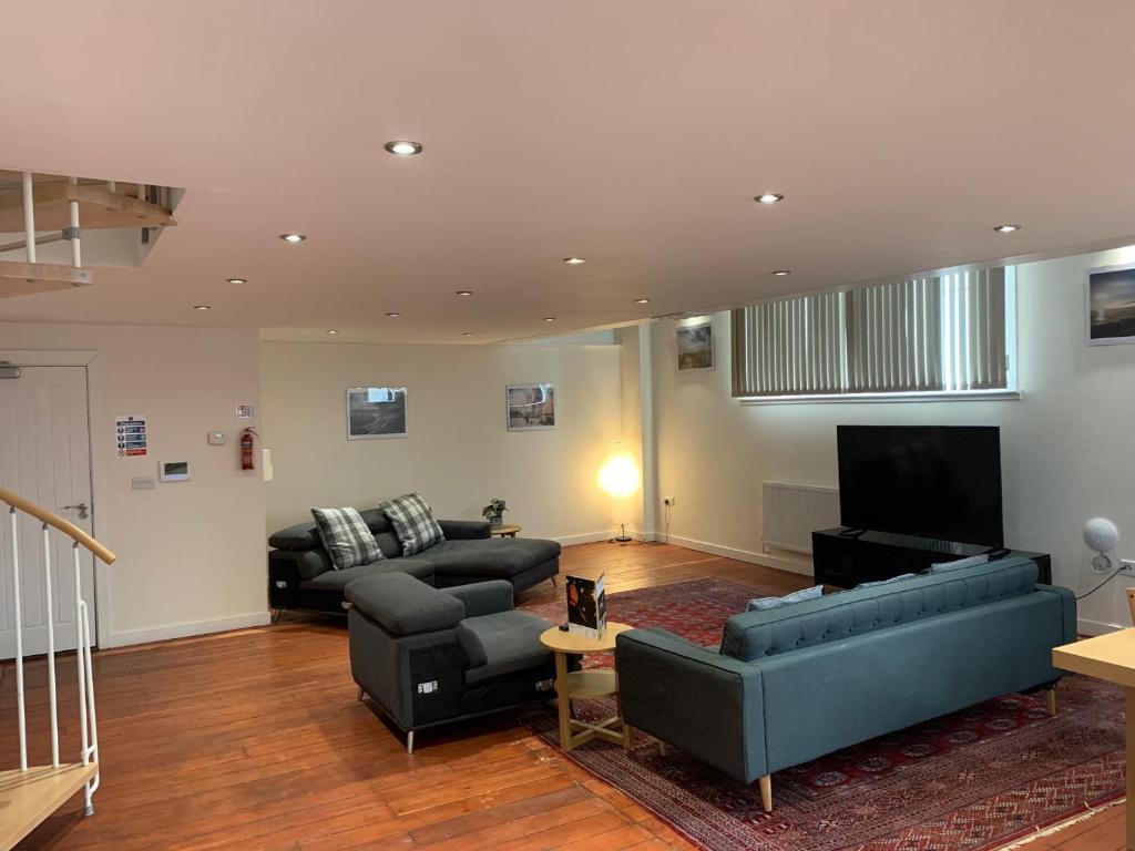 a living room with two couches and a television at Charter House School Serviced Apartments - Hull Serviced Apartments HSA in Hull