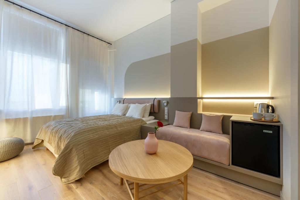 um quarto com uma cama, um sofá e uma mesa em Laisves ave. Apartments Mini em Kaunas