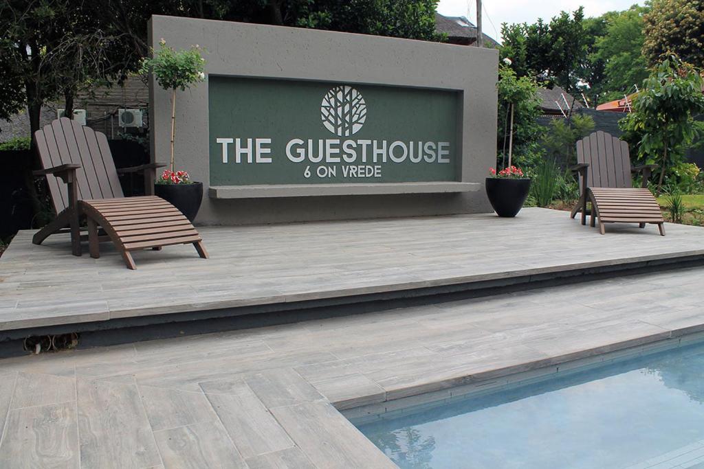 two chairs sitting on a deck next to a swimming pool at The Guesthouse 6 on Vrede in Johannesburg