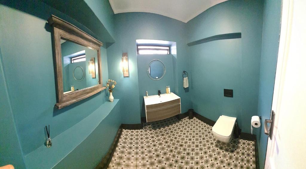 a blue bathroom with a sink and a toilet at The Guesthouse 6 on Vrede in Johannesburg