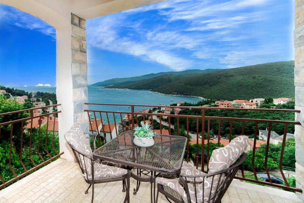 a balcony with a table and chairs and a view of the water at Apartments Marina in Rabac