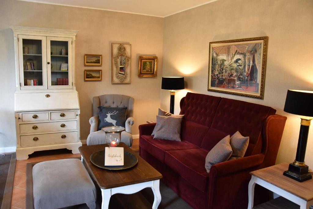 - un salon avec un canapé rouge et une chaise dans l'établissement Luxus-Ferienwohnung-Kaminzeit, à Hahnenklee