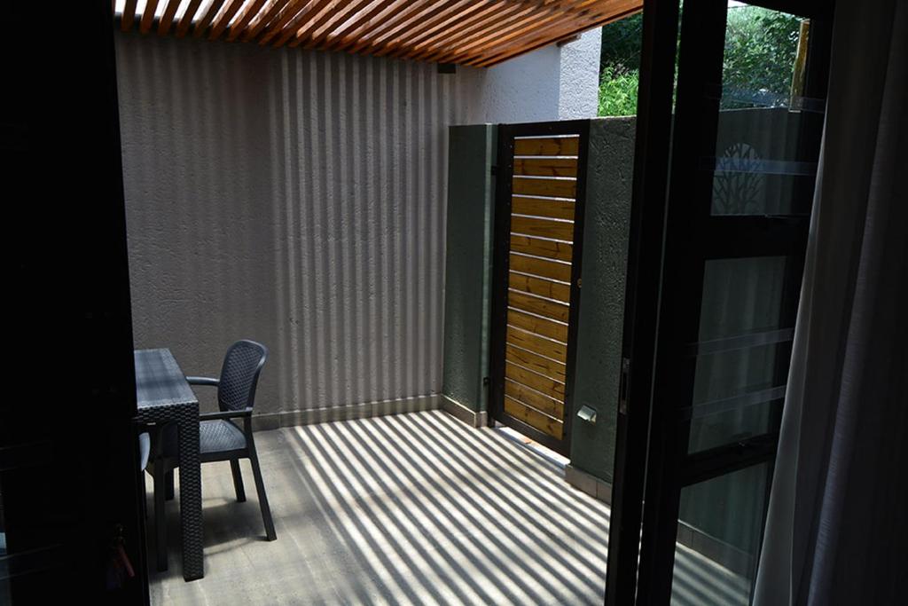 a balcony with a table and chairs and a door at The Guesthouse 6 on Vrede in Johannesburg