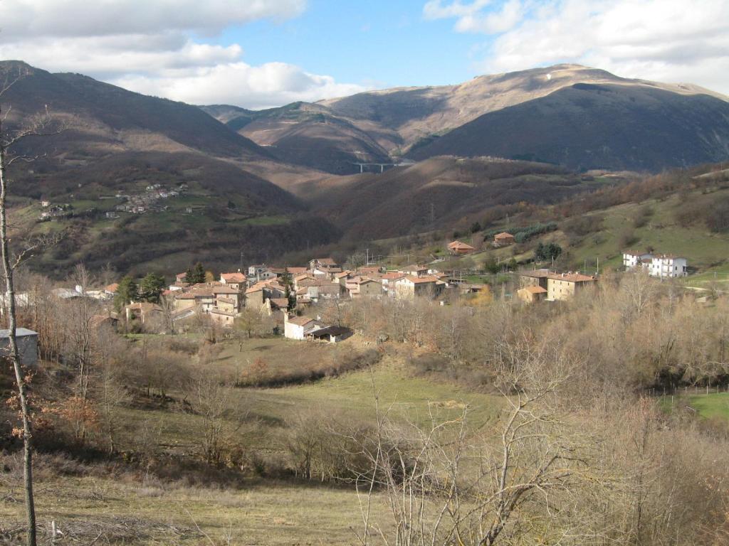 a town on a hill with mountains in the background at Lago Secco Bed & Breakfast Country House in Accumoli