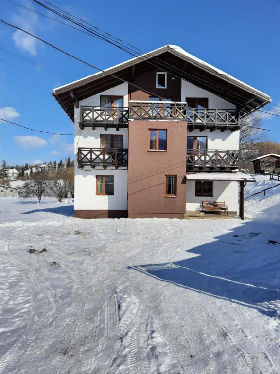 a snow covered ski slope with a building at Guest House Stari Druzy in Slavske