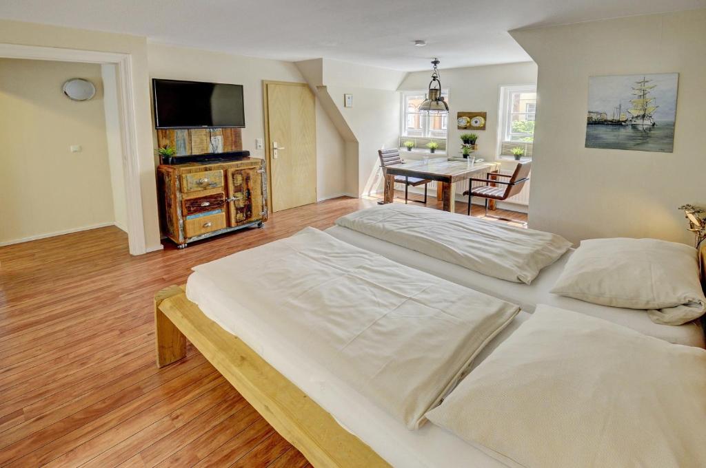 a large white bed in a room with a dining room at fewo1846 - Kajuete am Nordermarkt - maritim eingerichtetes Studio-Apartment im Stadtzentrum in Flensburg