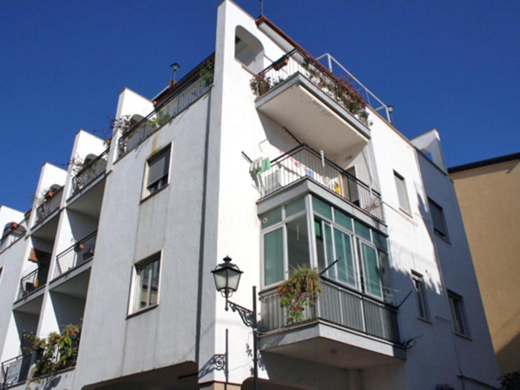 a white apartment building with balconies and a street light at Apartment Angelina by Interhome in Sorrento