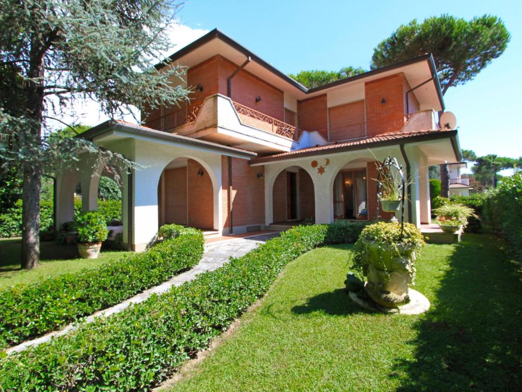 ein Haus mit einem grünen Hof mit einer Pflanze in der Unterkunft Villa Marcella by Interhome in Forte dei Marmi