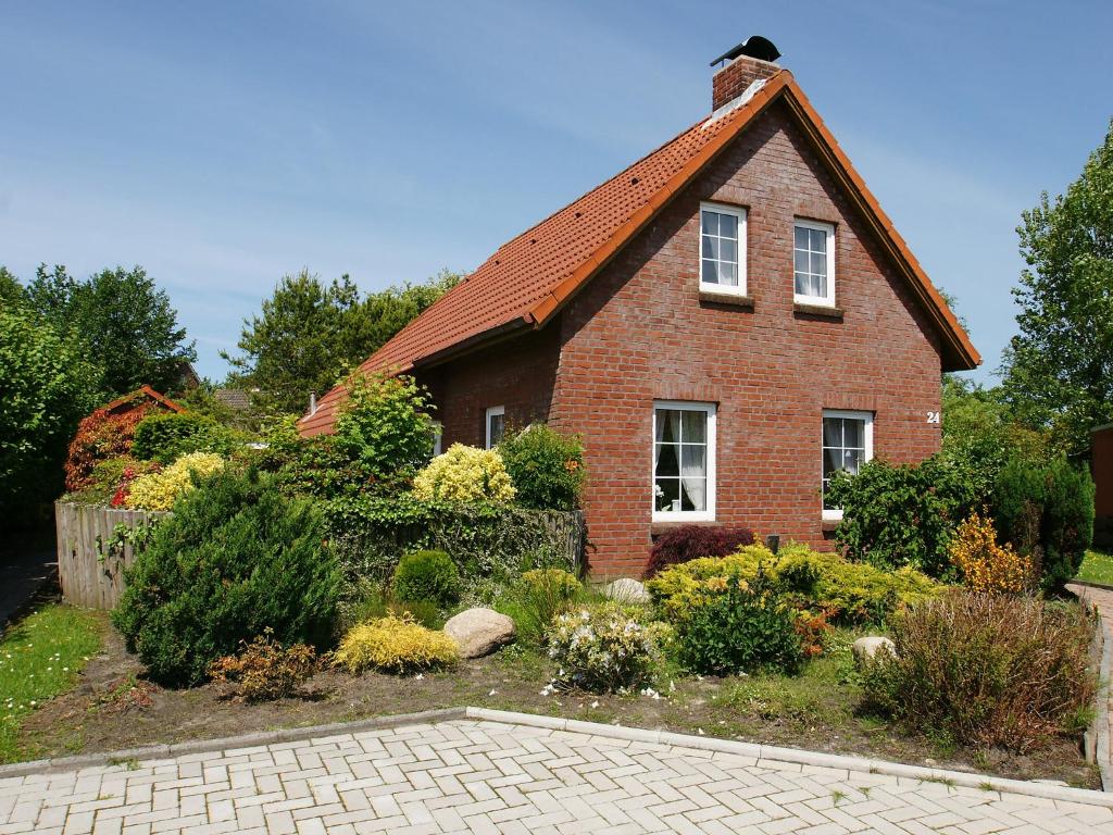 a brick house with a garden in front of it at Holiday Home Riedehuus by Interhome in Norddeich