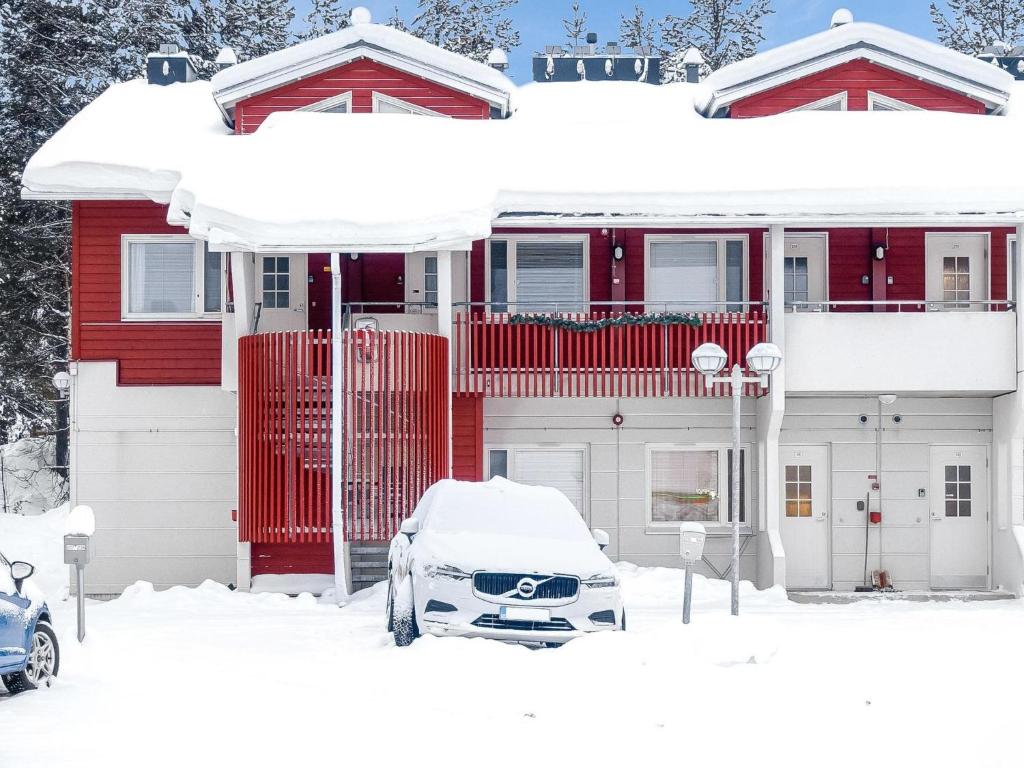 a snow covered house with a car parked in front of it at Holiday Home Moonlight 111 by Interhome in Levi