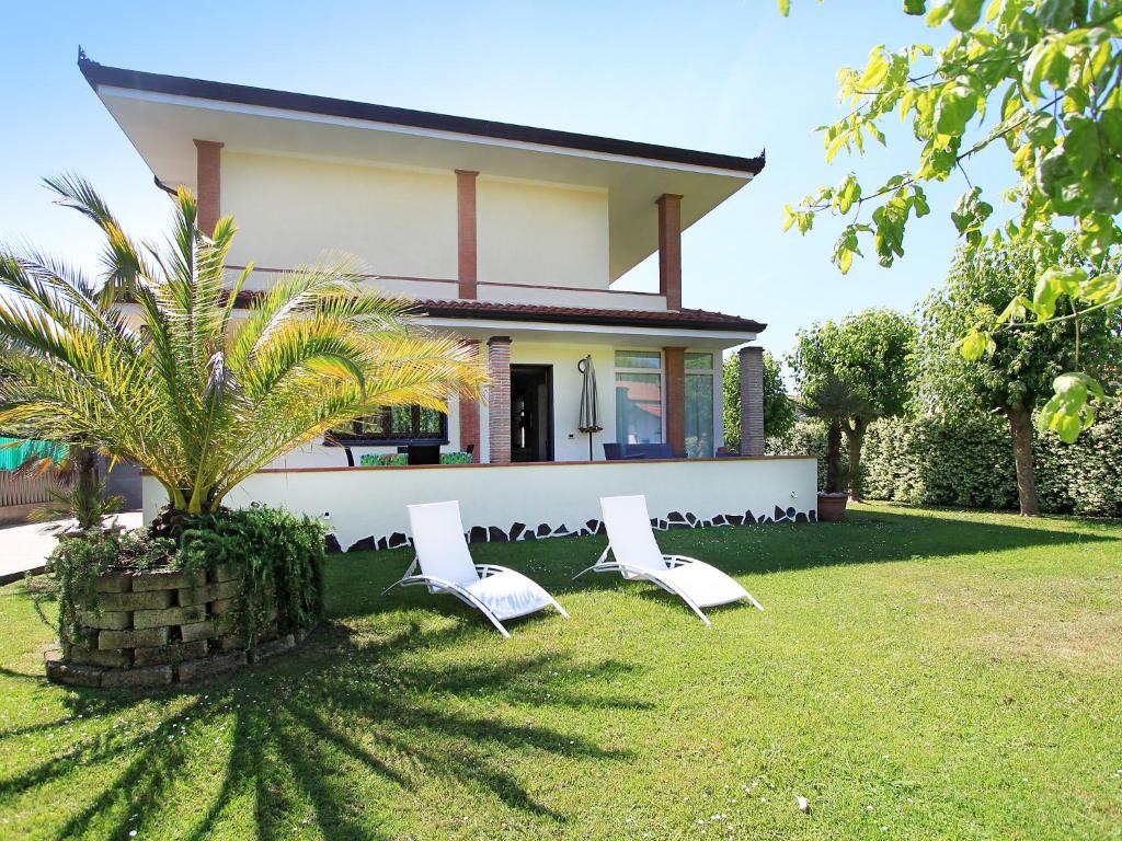 two white chairs sitting in front of a house at Villa Villa Chiara by Interhome in Forte dei Marmi