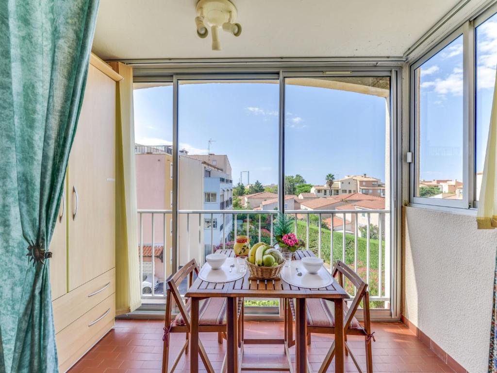a dining room with a table and chairs and a large window at Apartment Plein Soleil-1 by Interhome in Cap d'Agde