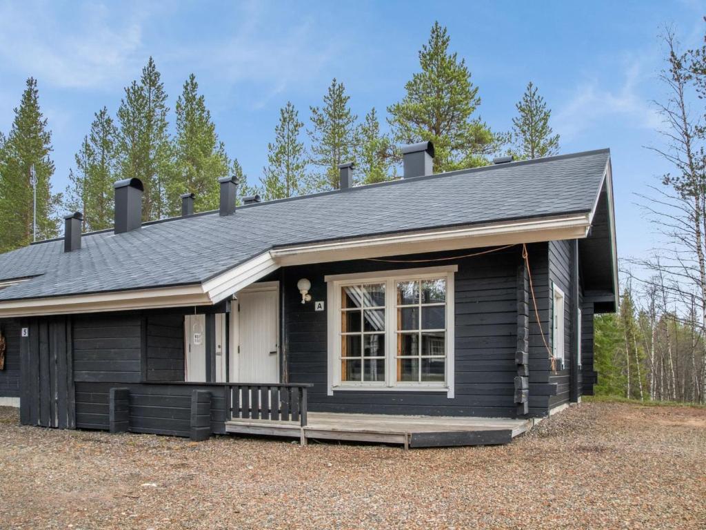 ein kleines schwarzes Haus mit einer Veranda in der Unterkunft Holiday Home Lomaylläs h113-pistopolku 5a by Interhome in Ylläsjärvi