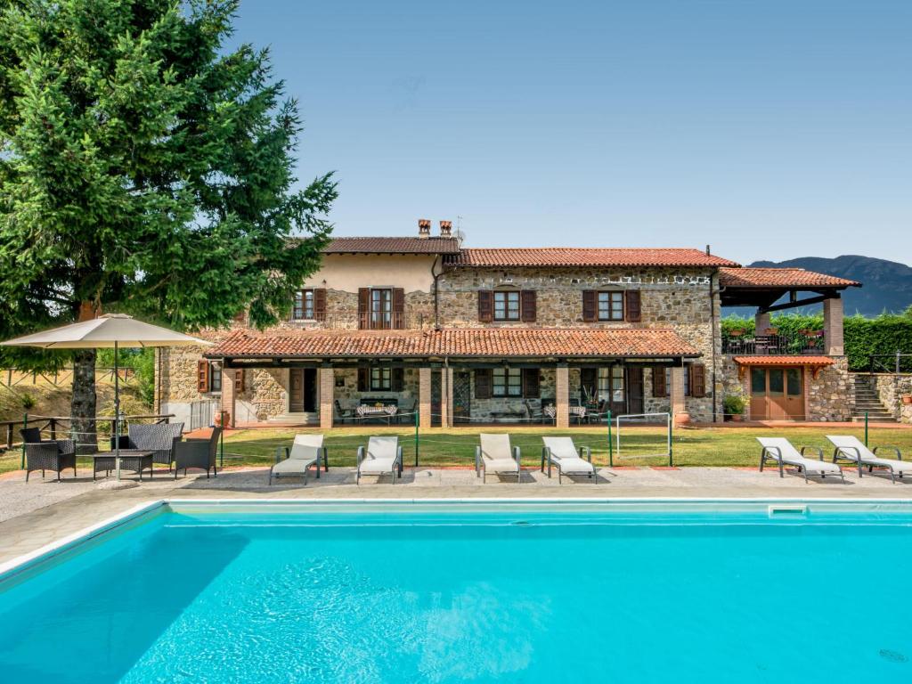 a villa with a swimming pool in front of a house at Holiday Home La Fenice by Interhome in Vitoio