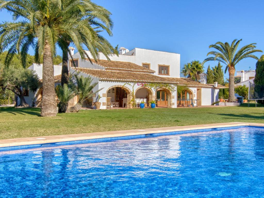 a villa with a swimming pool in front of a house at Holiday Home El Torrero by Interhome in Benitachell