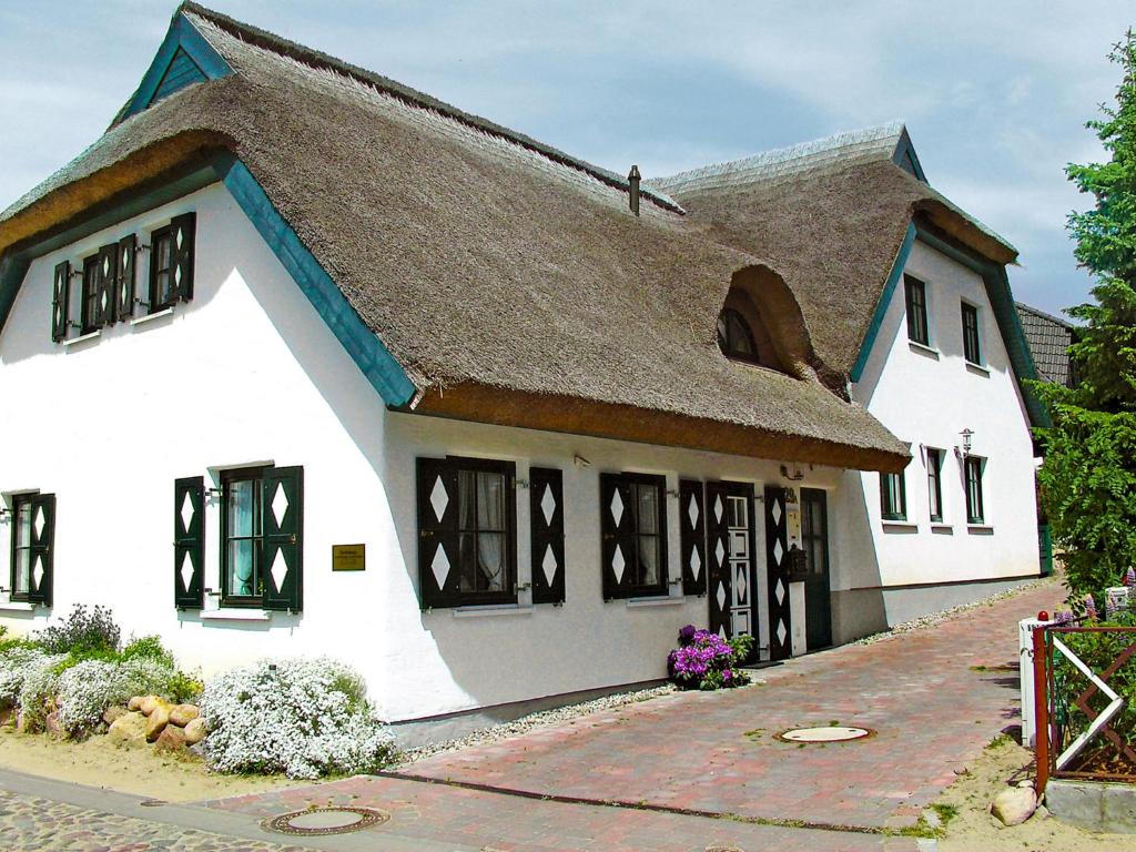 ein großes weißes Gebäude mit braunem Dach in der Unterkunft Holiday Home Kapitänshaus by Interhome in Groß Zicker