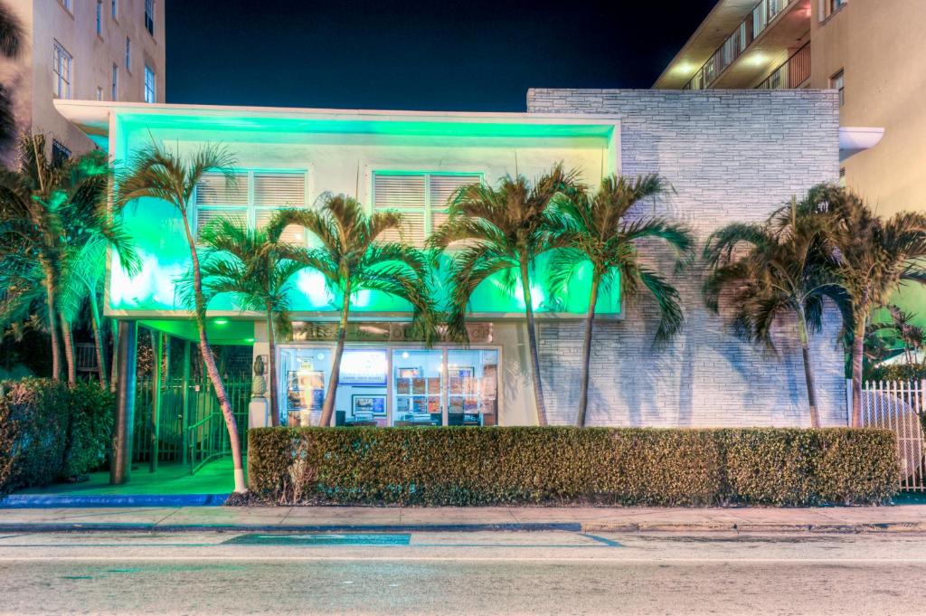 a building with palm trees in front of it at Suites on South Beach in Miami Beach