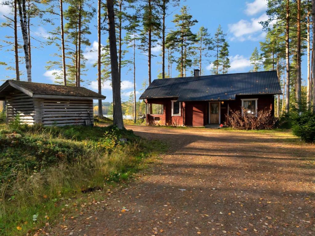 una cabaña de madera y un pequeño edificio en el bosque en Holiday Home Kuusikumpu by Interhome, en Petäjävesi