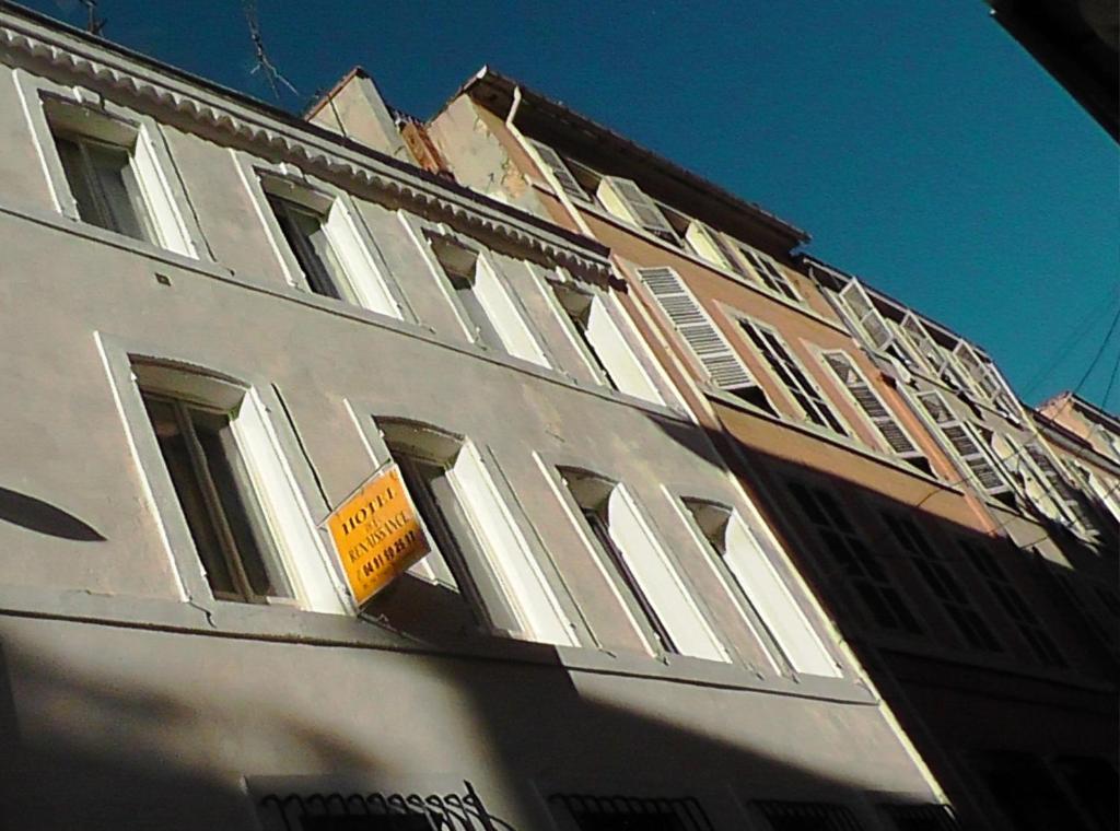 a white building with a yellow sign on the side of it at Hôtel de la Renaissance in Marseille
